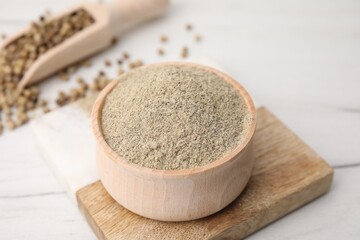 Aromatic spice. Ground pepper in bowl on white wooden table, closeup