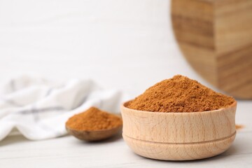 Aromatic spice. Ground red pepper in bowl on white wooden table, closeup. Space for text