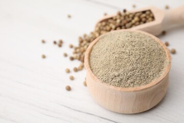 Aromatic spice. Ground pepper in bowl and scoop with peppercorns on white wooden table, closeup....