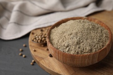Aromatic spice. Ground pepper in bowl and peppercorns on grey wooden table, closeup. Space for text