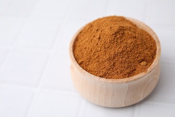 Ground red pepper on white tiled table, closeup. Space for text