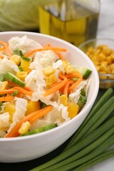Tasty salad with Chinese cabbage, carrot, corn, cucumber and green onion on table, closeup