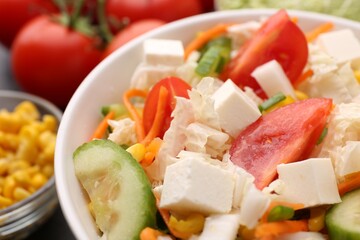 Tasty salad with Chinese cabbage, carrot, cheese, cucumber and tomato on table, closeup