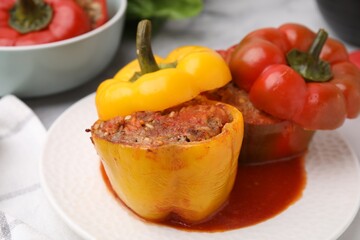 Delicious stuffed bell peppers served on white marble table, closeup