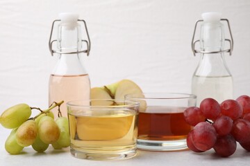 Different types of vinegar and ingredients on light table, closeup