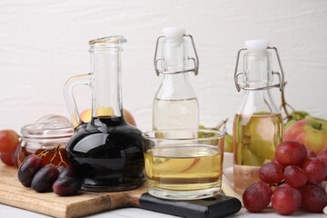 Different types of vinegar and fresh fruits on table
