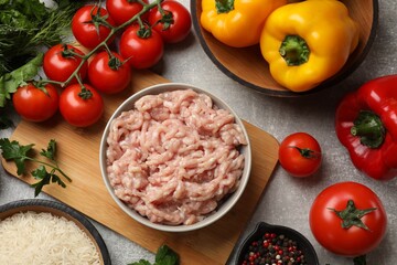 Making stuffed peppers. Ground meat and other ingredients on grey table, flat lay