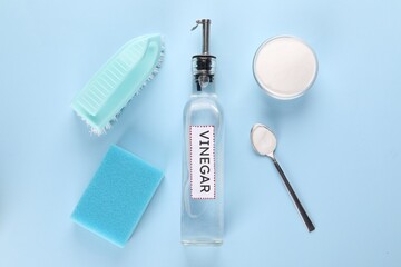 Eco friendly natural cleaners. Flat lay composition with bottle of vinegar on light blue background