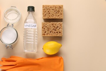 Eco friendly natural cleaners. Flat lay composition with bottle of vinegar on beige background,...