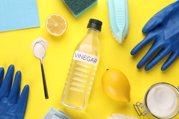 Eco friendly natural cleaners. Flat lay composition with bottle of vinegar on yellow background