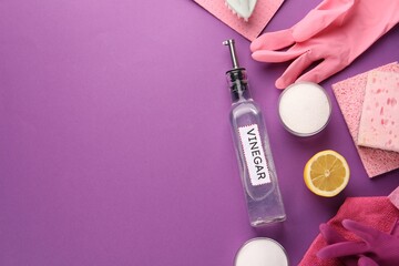 Eco friendly natural cleaners. Flat lay composition with bottle of vinegar on purple background, space for text