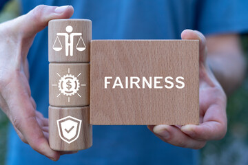 Man holding wooden blocks sees word: FAIRNESS. Business ethics, compliance and fairness concept....