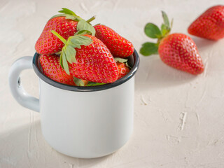Fresh red strawberries in metal cup. Strawberry in rustic cup on oriental white background