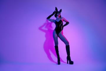 Photo of girl wear black leather rabbit costume touch mask look neon ultraviolet color background