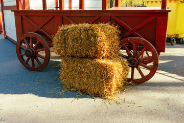 a pair of haystacks on the background of a wooden cart