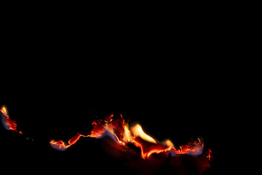 burning paper, glowing edge of paper on a black background.
