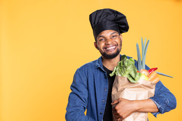 African american male chef buying fresh groceries to prepare a special vegan recipe, feeling...