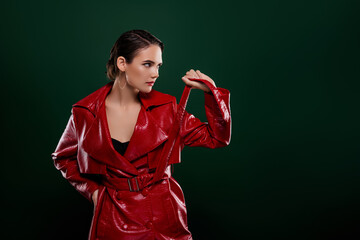 Photo of brunette hair girl touch belt red leather jacket posing look empty space isolated green...