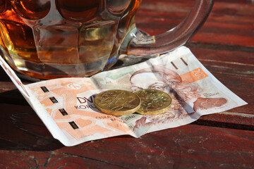 Money - Czech crowns placed on the table next to a pint of beer, ready to be paid for the beer