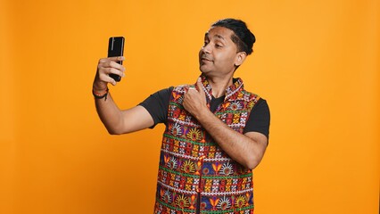 Indian narcissistic man using cellphone to take selfies from all angles. Vain social media user...
