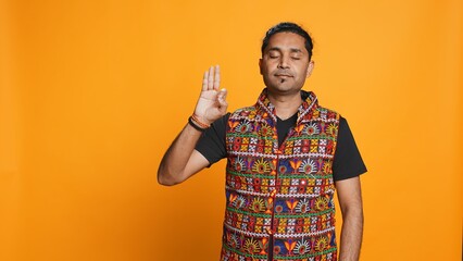 Indian man doing ok hand sign, feeling pleased, agreeing with satisfactory conclusion. Optimistic...
