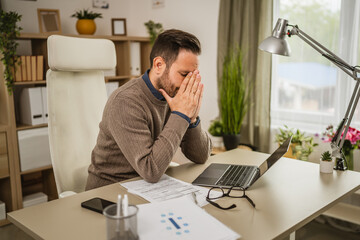Exhausted adult caucasian man have eyestrain while work at office