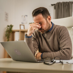 Exhausted adult caucasian man have eyestrain while work at office