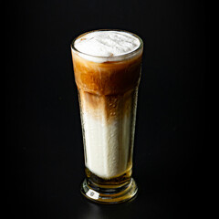 Iced hazelnut latte with milk foam topping, a refreshing and sweet coffee drink