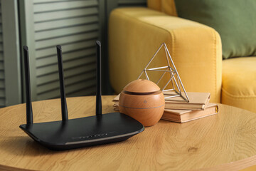 Modern wi-fi router with books on table in living room, closeup