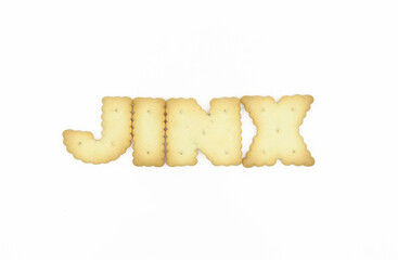 Capital letter shaped biscuits forming word JINX isolated on white background