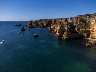 Praia de Dona Ana beach near Lagos town, Algarve, Portugal. Praia Dona Ana beach with turquoise sea water and cliffs, Portugal. Drone aerial view