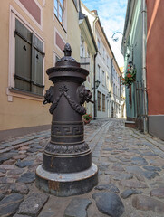 Bollard to restrict the movement of cars, decorative column on sidewalk of city street. The pole...