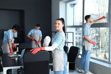 Female janitor with pp-duster cleaning in office