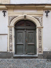Vintage wooden entrance door in a old retro building facade.