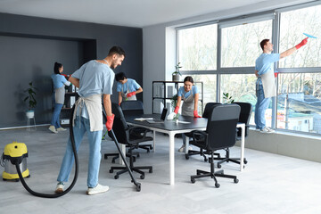 Team of janitors cleaning in office