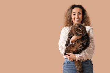 Beautiful mature woman with cute cat on brown background