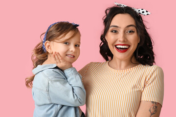 Happy pin-up woman and her daughter on pink background
