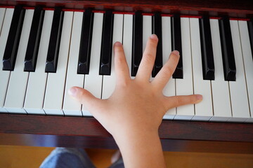 0歳小学4年生の子どもが電子ピアノを弾いている手元。
