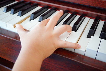 10歳小学4年生の子どもが電子ピアノを弾いている手元。オクターブがギリギリ届く。