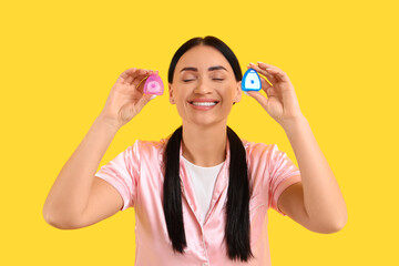 Beautiful young happy woman with different dental floss on yellow background
