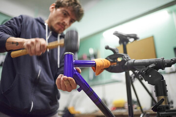 Young latin repairman assembling a bicycle in his bike workshop as part of a maintenance service....