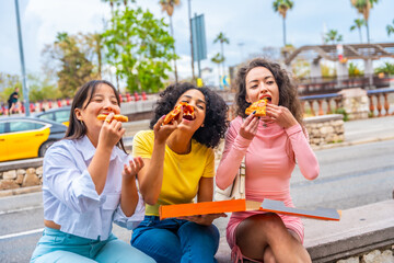 Friends having fun eating pizza in the city