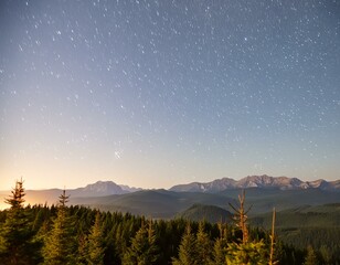 Fototapeta premium a night sky filled with stars and a mountain range in the distance.