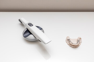 Bridge Printed By 3d Printer on Table. 3D Intraoral Teeth Scanner For Imaging Tooth and Metal Frame Lower Partial Denture, Cobalt Chrome Dental Plate. No People. Dental Equipment, Device, Dentistry.