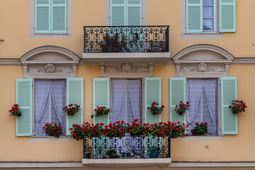 Architectural fragments of the facades of ancient houses in Nice: beautiful windows, balconies, shutters. Nice, capital of the Alpes-Maritimes department on the French Riviera.