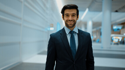 Smiling business man looking at camera while standing at white background. Closeup of successful...
