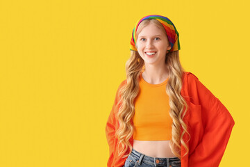 Beautiful young happy woman in rainbow bandana on yellow background. LGBTQ concept