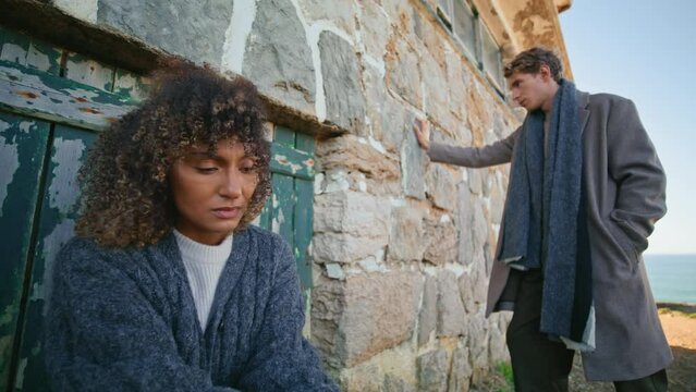 Breakup couple feeling sad at chateau near ocean. Models posing abandoned place