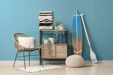 Interior of living room with surfboard, shelf unit and armchair