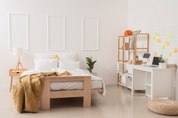 Interior of student's bedroom with table and shelf unit